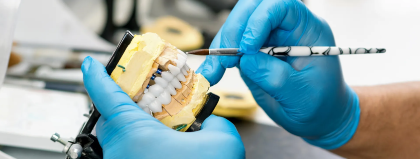 un dentiste entrain de travailler l'estethique d'un dentier