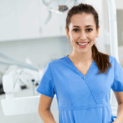 Assistante dentaire souriante en blouse bleue dans un cabinet moderne