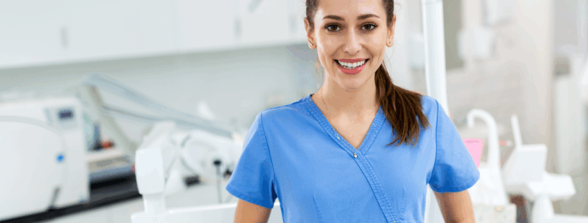 Assistante dentaire souriante en blouse bleue dans un cabinet moderne