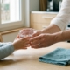 Parent tendant un verre d'eau à un jeune enfant assis à table