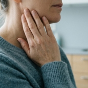 Main posée contre la mâchoire, signe d’une ouverture de bouche limitée Main posée contre la mâchoire, signe d'une ouverture de bouche limitée