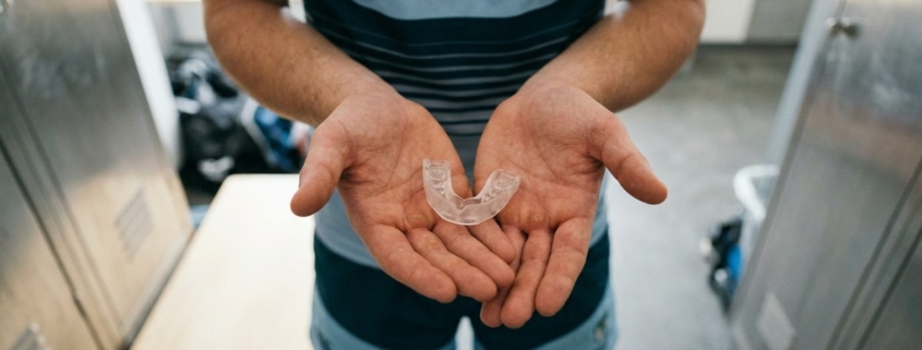 Protège-dents sur mesure tenu dans les mains d'un sportif