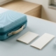 Petite valise de voyage, carnet et modèle dentaire sur fond clair