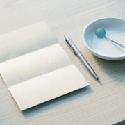 Document plié, stylo et miroir dentaire disposés sur un plan en chêne