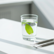 Verre d'eau et feuille de menthe évoquant une haleine fraîche, en cabinet à Genève