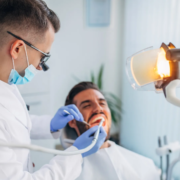 un dentiste en blouse en train de faire son travail avec un patient