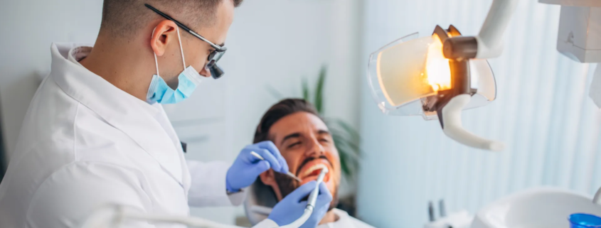 un dentiste en blouse en train de faire son travail avec un patient
