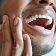 un homme qui a une douleur à la machoire