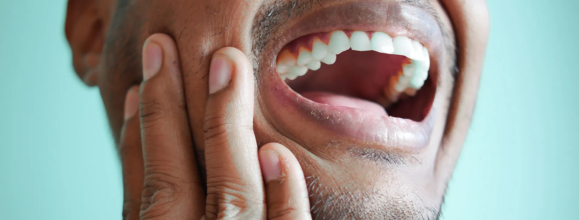 un homme qui a une douleur à la machoire